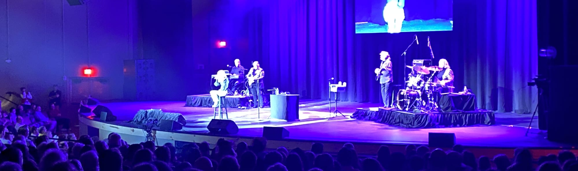 signer on stage in chair washed out by the lights Albany